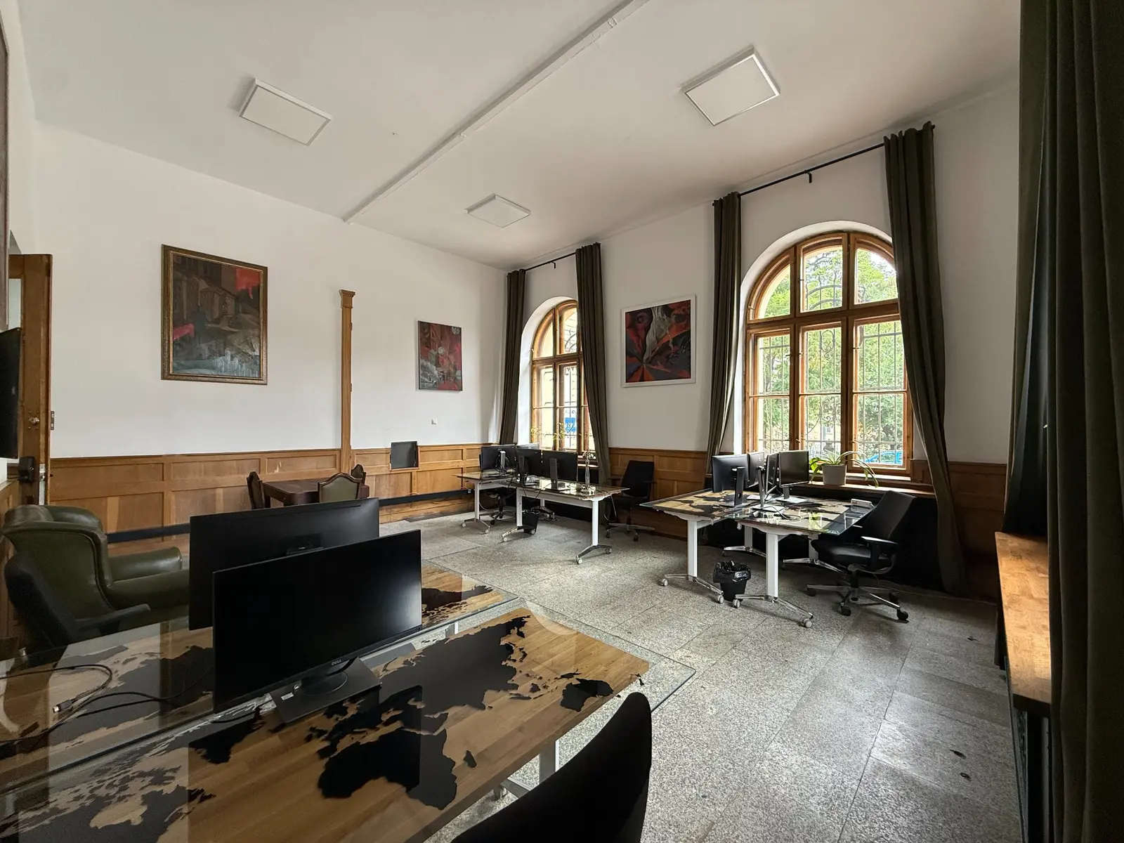Coworking z wysokimi oknami i stanowiskami z monitorami